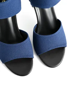 Macro detail view showing the blue fly-knit mesh texture of elegant peep-toe sandals