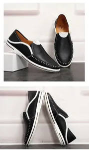 Detailweergave van zwarte handgestikte leren loafers voor heren met witte rubberen zool