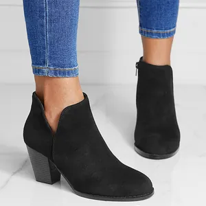 Detailed side view of black suede ankle boots featuring a chunky heel and V-cut side design
