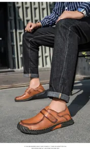 Detailopname van bruine vintage heren loafers van leer met handgestikte details.