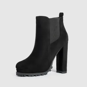 Close-up side view of a black suede Chelsea boot featuring a high chunky heel and platform.