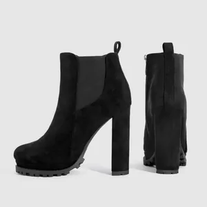 Detail of black suede Chelsea ankle boots with chunky high heels and lug soles