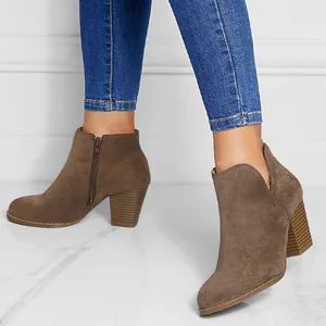 Detail view of brown suede ankle boots featuring chunky heels and side zipper closure.