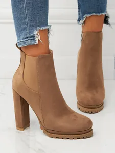 Macro detail of brown suede high heel Chelsea boots featuring elastic side panels