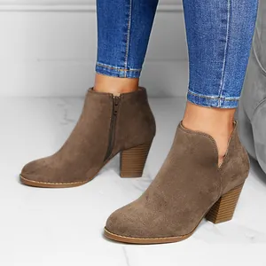 Detail view of stylish brown suede ankle boots featuring a chunky heel and side V-cut