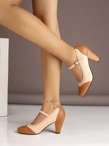 Detailed side view of brown and beige chunky heel Mary Jane pumps with retro brogue detailing