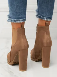 Detailed rear view of stylish brown suede Chelsea boots with chunky high heels and zip.