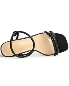 Detailed macro view of square toe sandal with clear strap and black knot detail.