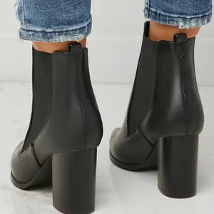 Detail view from behind showing the chunky heel and black leather of these ankle boots
