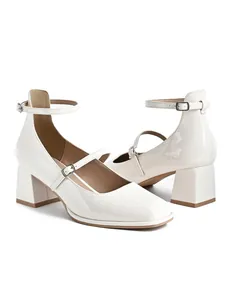 Elegant white patent leather Mary Jane shoes with block heels and adjustable ankle straps.