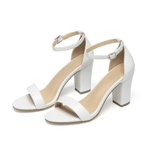 Elegant white chunky heel sandals featuring adjustable ankle straps and a minimalist design
