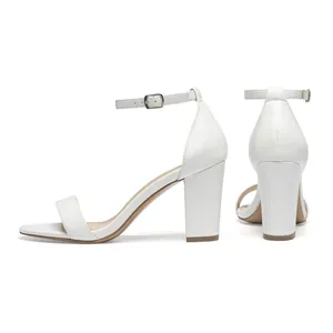 Elegant white block heel sandals with adjustable ankle strap and chunky high heel.
