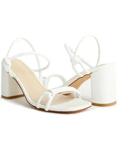 Detailed view of white square toe sandals with chunky block heels and knotted straps.