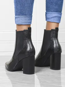 Macro detail of black snakeskin chunky heel ankle boots with elastic side panels