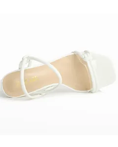 Detailed view of the insole and white straps of a stylish square-toe high-heel sandal.