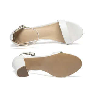 High-resolution detail of white block heel sandals showing the insole and sole grip.