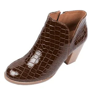 Detail of brown crocodile pattern ankle boot with chunky heel and side zipper