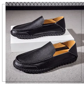 Close-up of black pebble grain leather men's driving loafers on a white pedestal