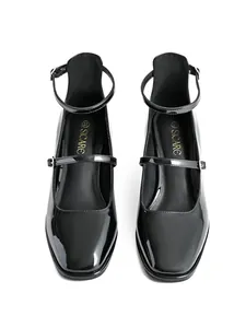 Detail view of black patent leather Mary Jane shoes with square toe and chunky heel