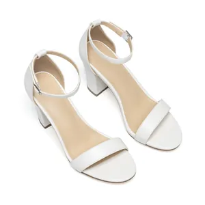 Close-up of white block heel sandals with adjustable ankle strap and silver buckle