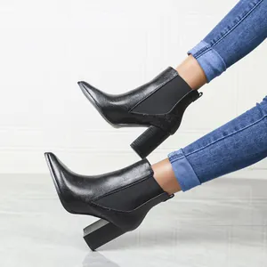Close-up view of pointed toe block heel ankle boots with embossed leather texture.