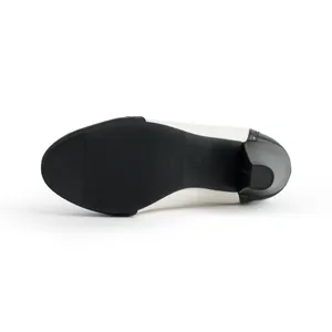 Detailed view of the non-slip black sole and block heel of a black and white pump shoe