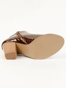 Detailed view of the block heel and sole on a brown croc-embossed ankle boot