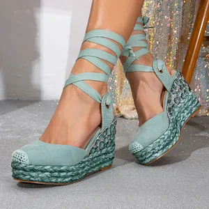 Close-up of mint green wedge sandals featuring sparkling rhinestones and lace-up straps.
