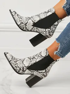 Detailed side view of women's snakeskin pattern pointed toe block heel ankle boots