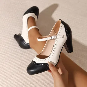 Vintage black and white Mary Jane high heels with brogue wingtip detailing and chunky heel.