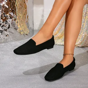 Detailweergave van ademende zwarte fly knit loafers gedragen door een model op glitter