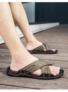Zijaanzicht detail van bruine leren strandsandalen voor heren op een houten terras