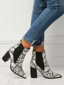 Stylish snakeskin pattern ankle boots with pointed toe and chunky block heel on model.