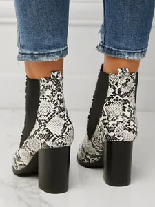 Close-up of snakeskin pattern chunky high heel ankle boots with elastic side panels.