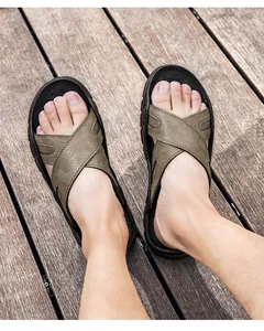 Gedetailleerd vooraanzicht van heren lederen sandalen met kruisbanden op houten vloer