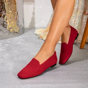 Ademende rode gebreide platte loafers met ronde neus in een stijlvolle woonomgeving