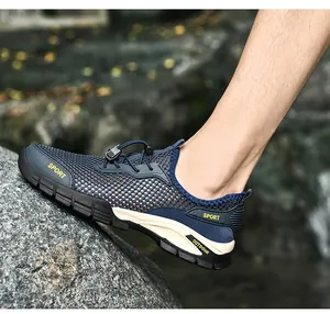 Dettaglio della scarpa sportiva da esterno in mesh traspirante blu navy da uomo sulla roccia