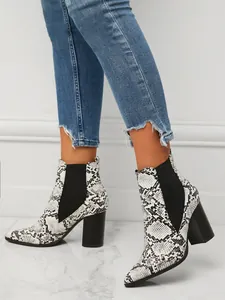 Stylish close-up view of snake skin pattern Chelsea ankle boots with chunky high heels