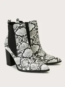 Detailed view of pointed toe block heel boots with black and white snakeskin pattern.