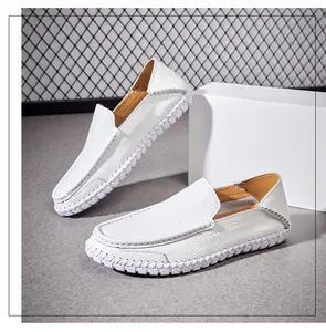 Close-up of white leather men's loafers with pebbled texture and hand-stitched details.