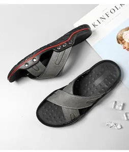 Gedetailleerd overzicht van stijlvolle grijze leren herensandalen met rode accenten