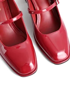 Close-up of glossy red patent leather square toe Mary Jane shoes with buckle strap