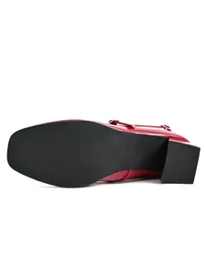 Detail view of the black non-slip sole and block heel of red Mary Jane shoes