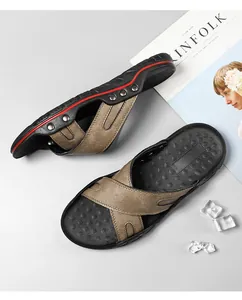 Detailopname van heren leren strandslippers met kruisbandontwerp en metalen klinknagels