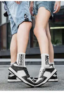 Λεπτομερής προβολή των unisex ασπρόμαυρων casual sneakers που φοράει ένα ζευγάρι
