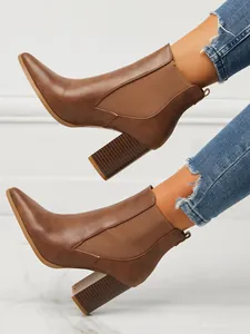 Detail view of brown pointed toe block heel ankle boots with elastic side panels.