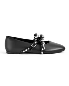 Detailed side view of black ballet flats featuring a studded bow and buckle ornament