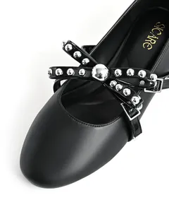 Detail shot of black round-toe flat with studded bow and buckle detail