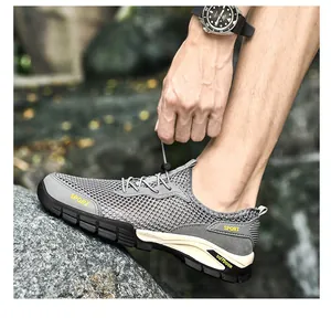 Vista dettagliata di scarpe outdoor da uomo in mesh grigio traspirante per il trekking estivo.