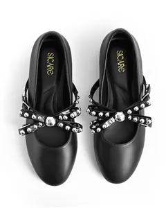 Top view of black round-toe ballet flats with silver rivet bow and brand SICARE on insole.